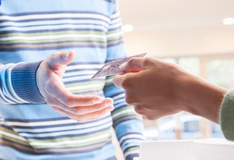 a person handing a credit card to another person