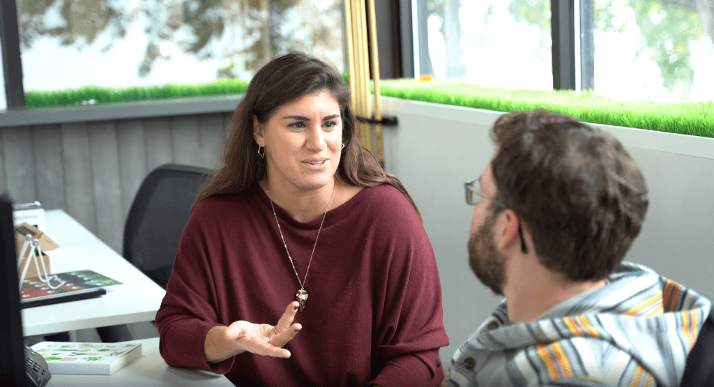a woman in a red sweater is talking to a man